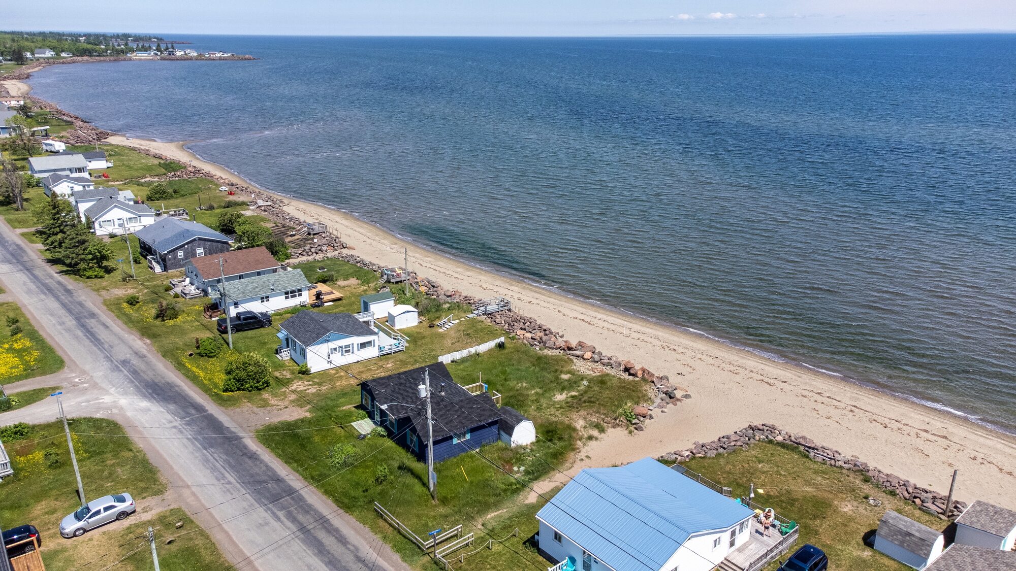 Aerial showing the cottage cluster and the long sand beach.