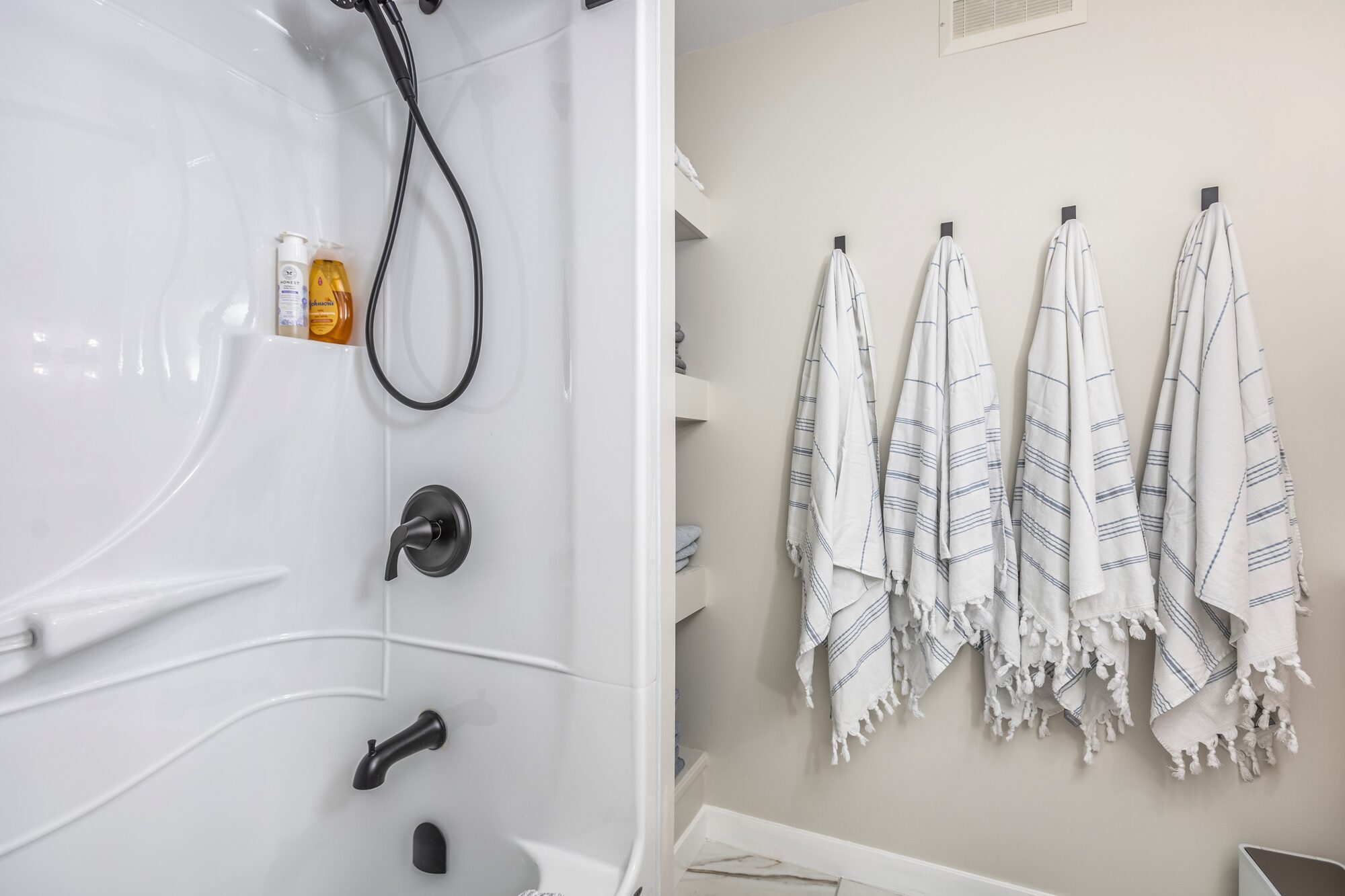 Bathroom with white-and-blue striped Turkish towels on hooks.